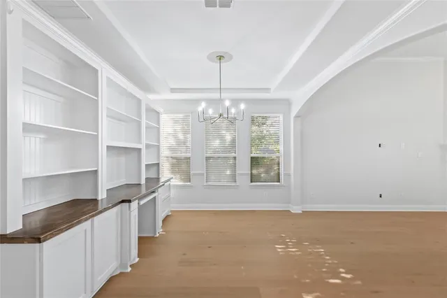 a dining room with furniture a chandelier and wooden floor