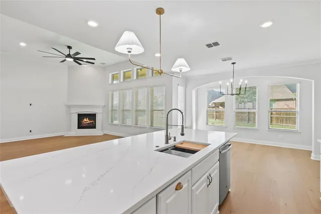 a kitchen with a sink a chandelier and living room view