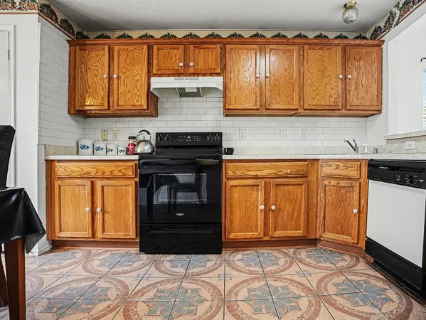 a kitchen with granite countertop a sink stove and cabinets