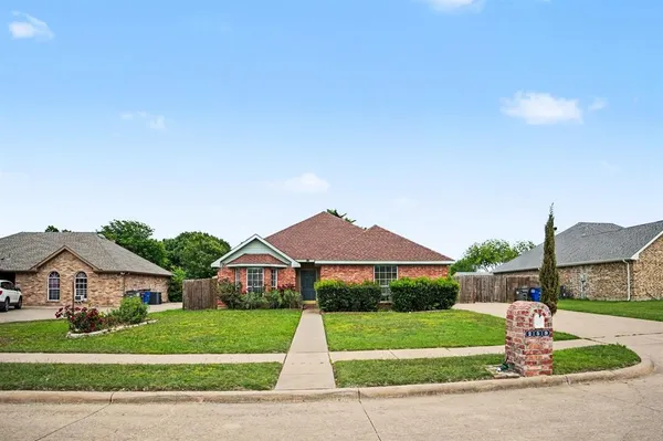 a front view of a house with a yard and trees