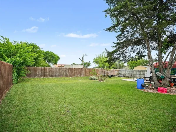 a view of a backyard with table and chairs and wooden fence