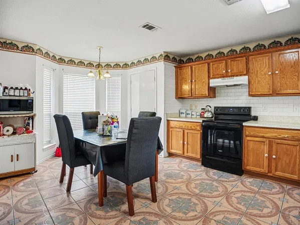 a kitchen with granite countertop a stove a sink and a refrigerator