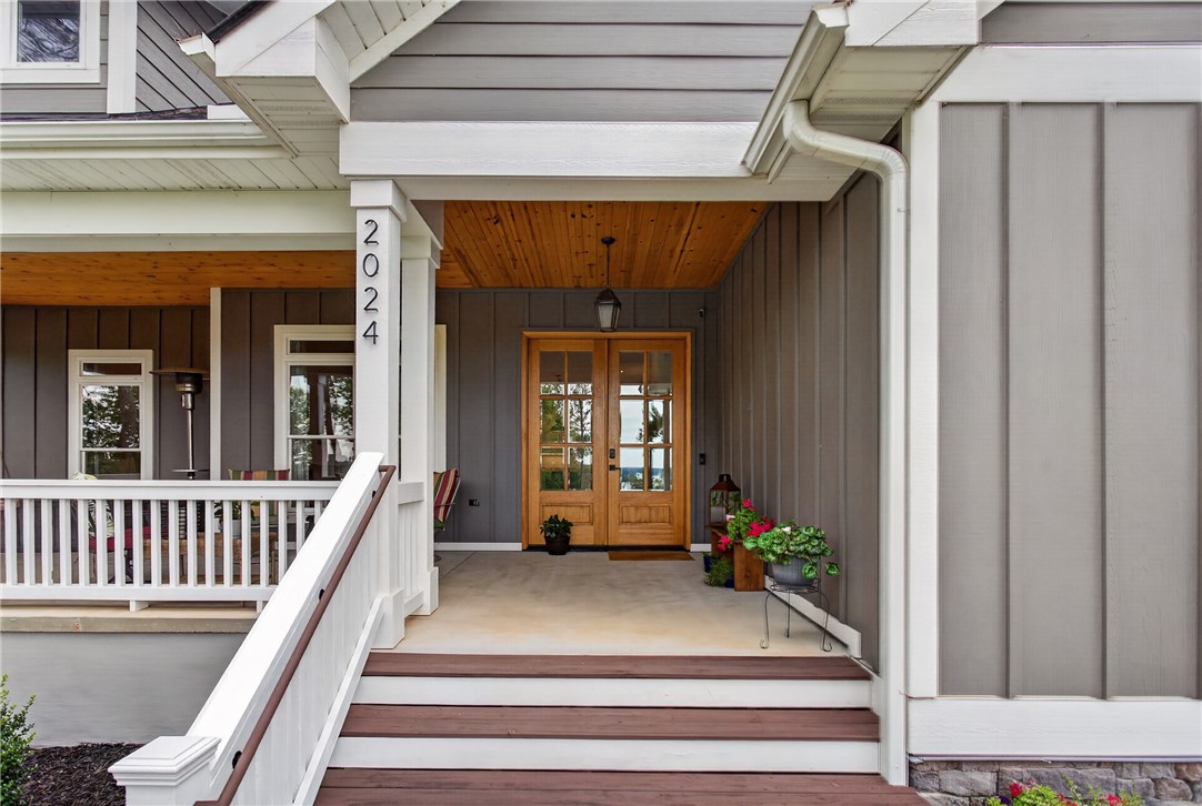 2024 Retreat Pointe Road West Union, SC 29696 - Photo 29 of 43 A welcoming front entry features double wood doors and a charming covered porch with a wood plank ceiling.