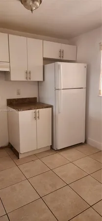 a view of a kitchen with cabinets and white appliances