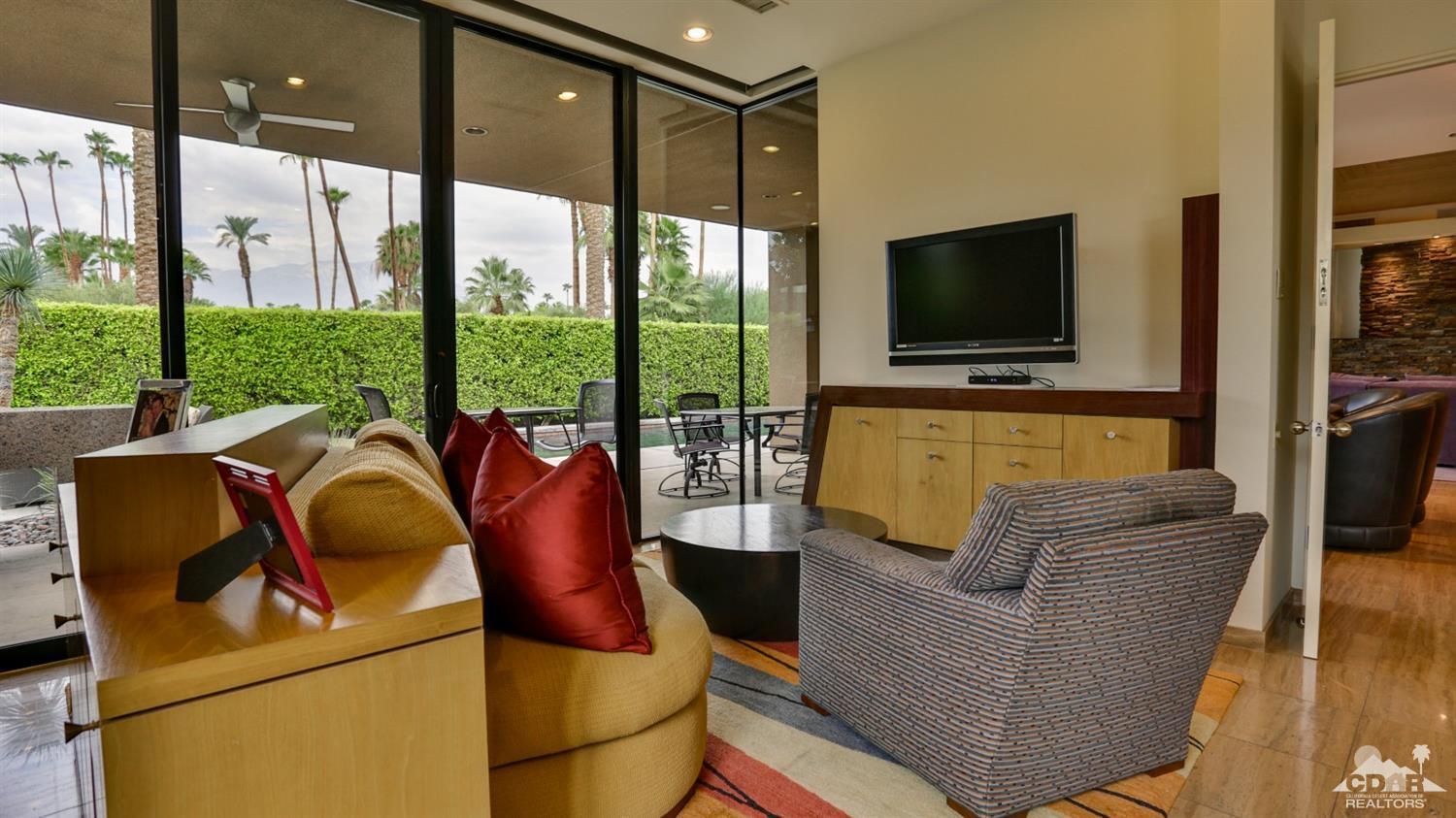 37 Sun Ridge Circle Rancho Mirage, CA 92270 - Photo 36 of 63 a living room with couches a flat screen tv and a floor to ceiling window