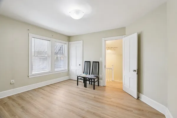a view of an empty room with a window and wooden floor