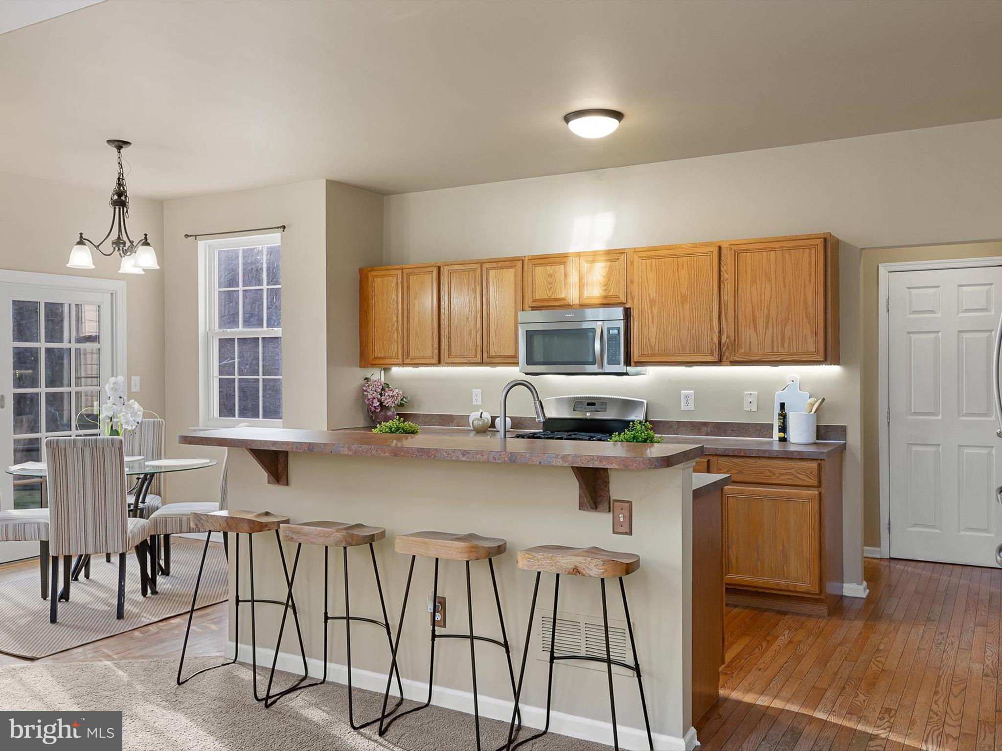 5 Meghan Lane Bear, DE 19701 - Photo 15 of 41 a kitchen with kitchen island granite countertop a table chairs microwave and cabinets