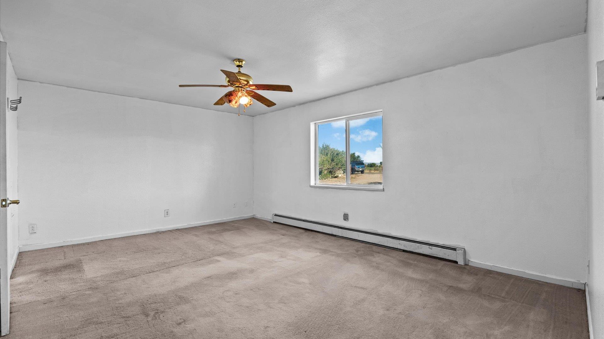1351 M M 1/4 Road Loma, CO 81524 - Photo 23 of 36 an empty room with a window and a ceiling fan