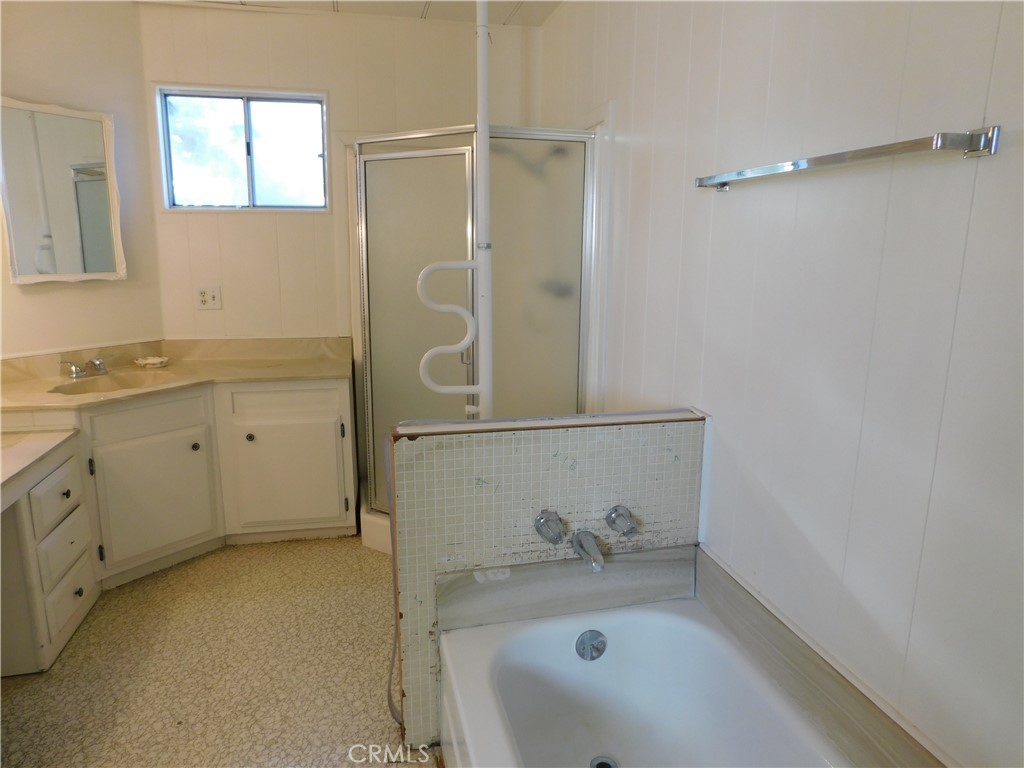 10675 Bryant Street, Unit 112 Yucaipa, CA 92399 - Photo 36 of 49 a bathroom with a granite countertop sink a mirror and shower