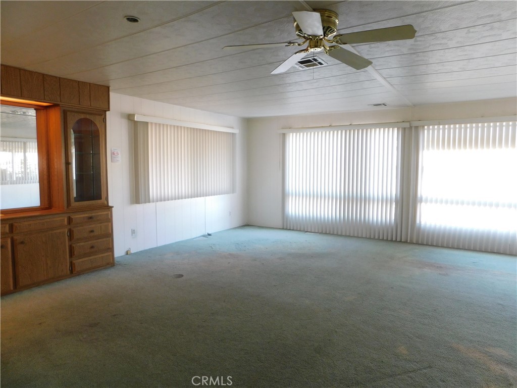 10675 Bryant Street, Unit 112 Yucaipa, CA 92399 - Photo 5 of 49 en empty room with windows and ceiling fan