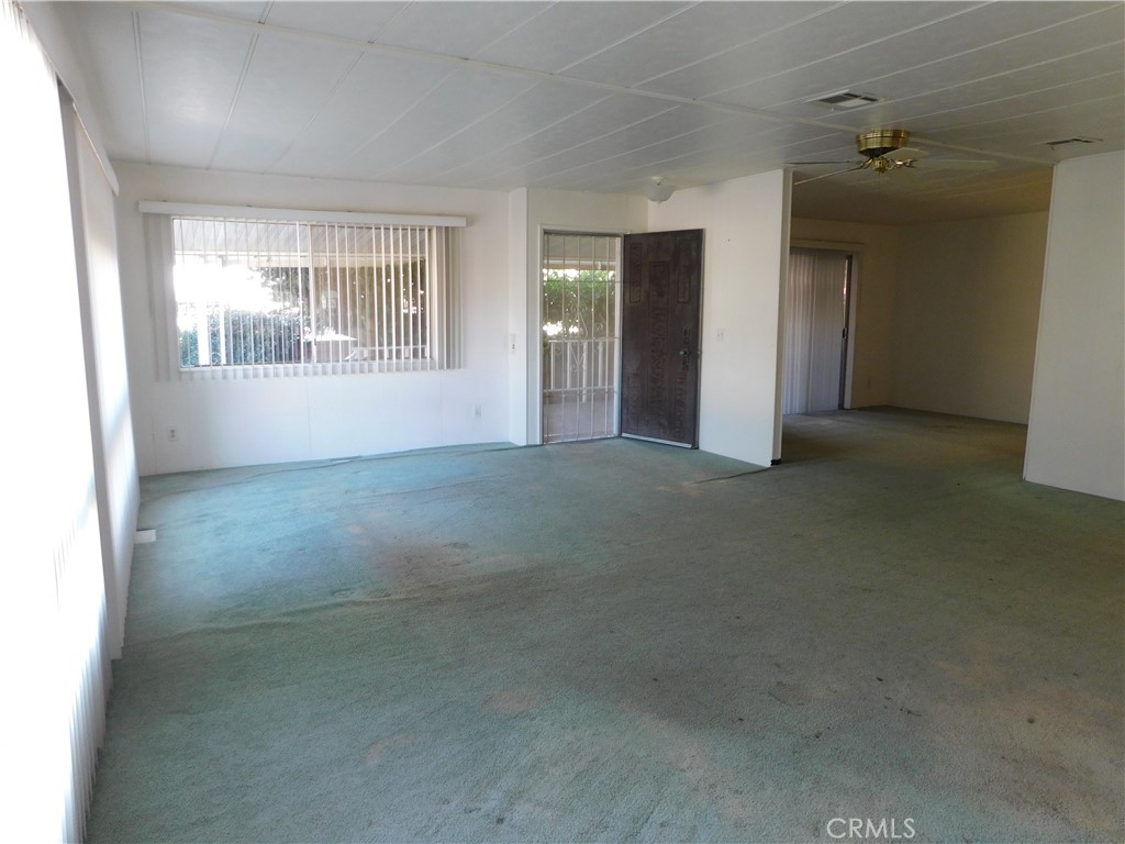 10675 Bryant Street, Unit 112 Yucaipa, CA 92399 - Photo 7 of 49 an empty room with windows and mirror