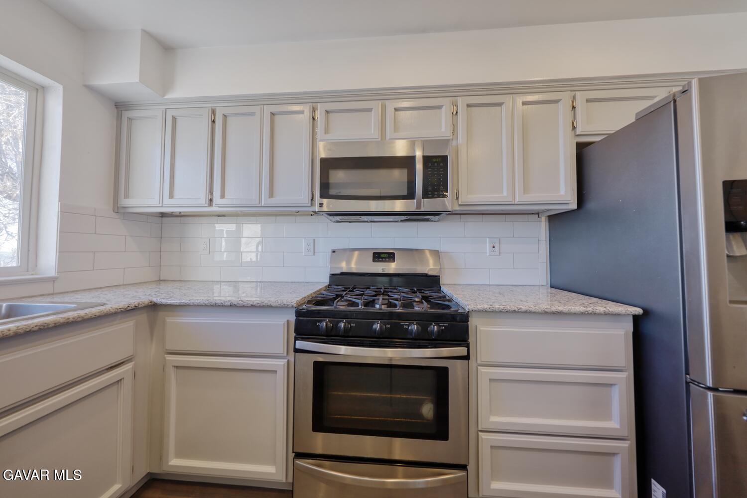 26801 Cabriolet Court Tehachapi, CA 93561 - Photo 14 of 60 a kitchen with stainless steel appliances granite countertop white cabinets and stove