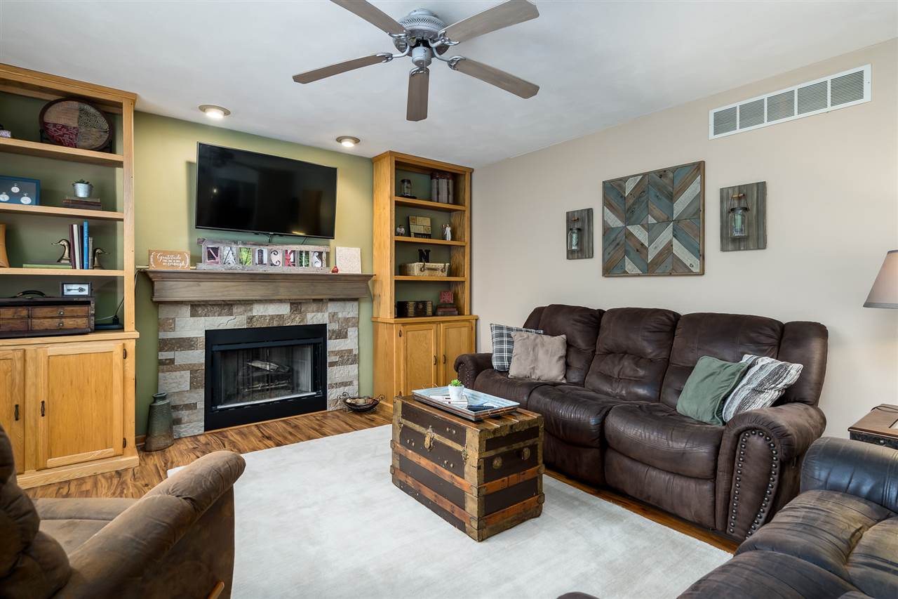 9414 Rambouillet Ridge Roscoe, IL 61073 - Photo 25 of 39 a living room with furniture a flat screen tv and a fireplace