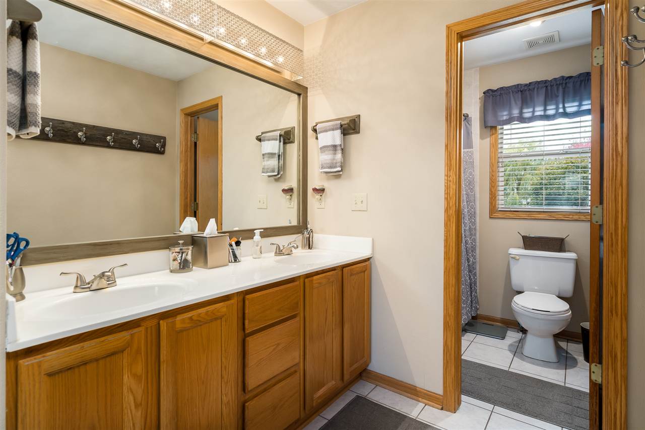 9414 Rambouillet Ridge Roscoe, IL 61073 - Photo 32 of 39 a bathroom with a granite countertop sink a toilet and a mirror