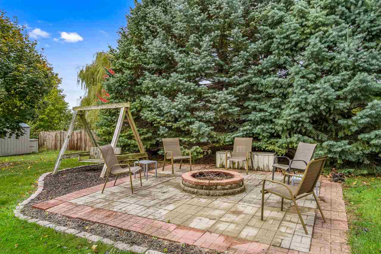 9414 Rambouillet Ridge Roscoe, IL 61073 - Photo 7 of 39 a view of a backyard with table and chairs potted plants and a palm tree