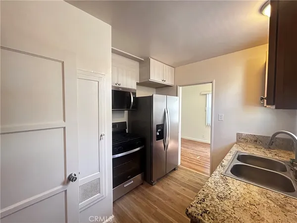 a kitchen with stainless steel appliances granite countertop a refrigerator and a stove