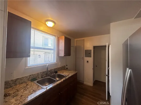 a kitchen with granite countertop stainless steel appliances a sink stove and refrigerator