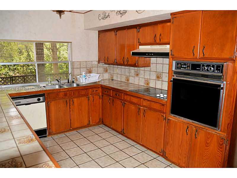 6440 Southwest 69th Avenue Miami, FL 33143 - Photo 12 of 20 a kitchen with stainless steel appliances a sink stove and cabinets
