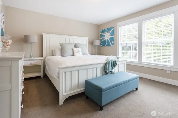 a bedroom with a bed table and a chair