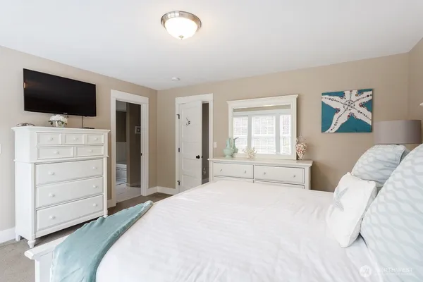 a bedroom with a large bed and a flat screen tv