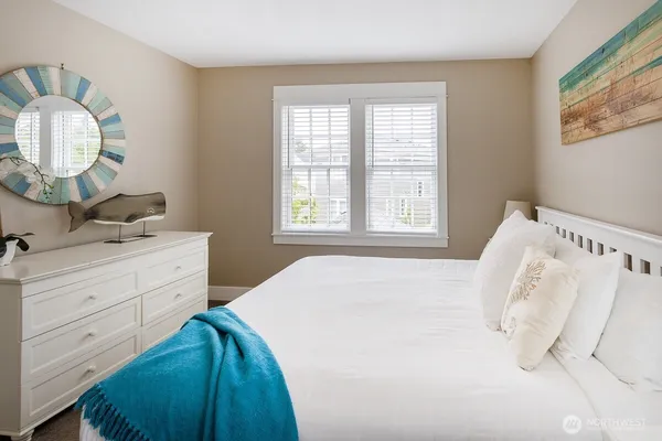 a bedroom with a bed and a mirror on dresser