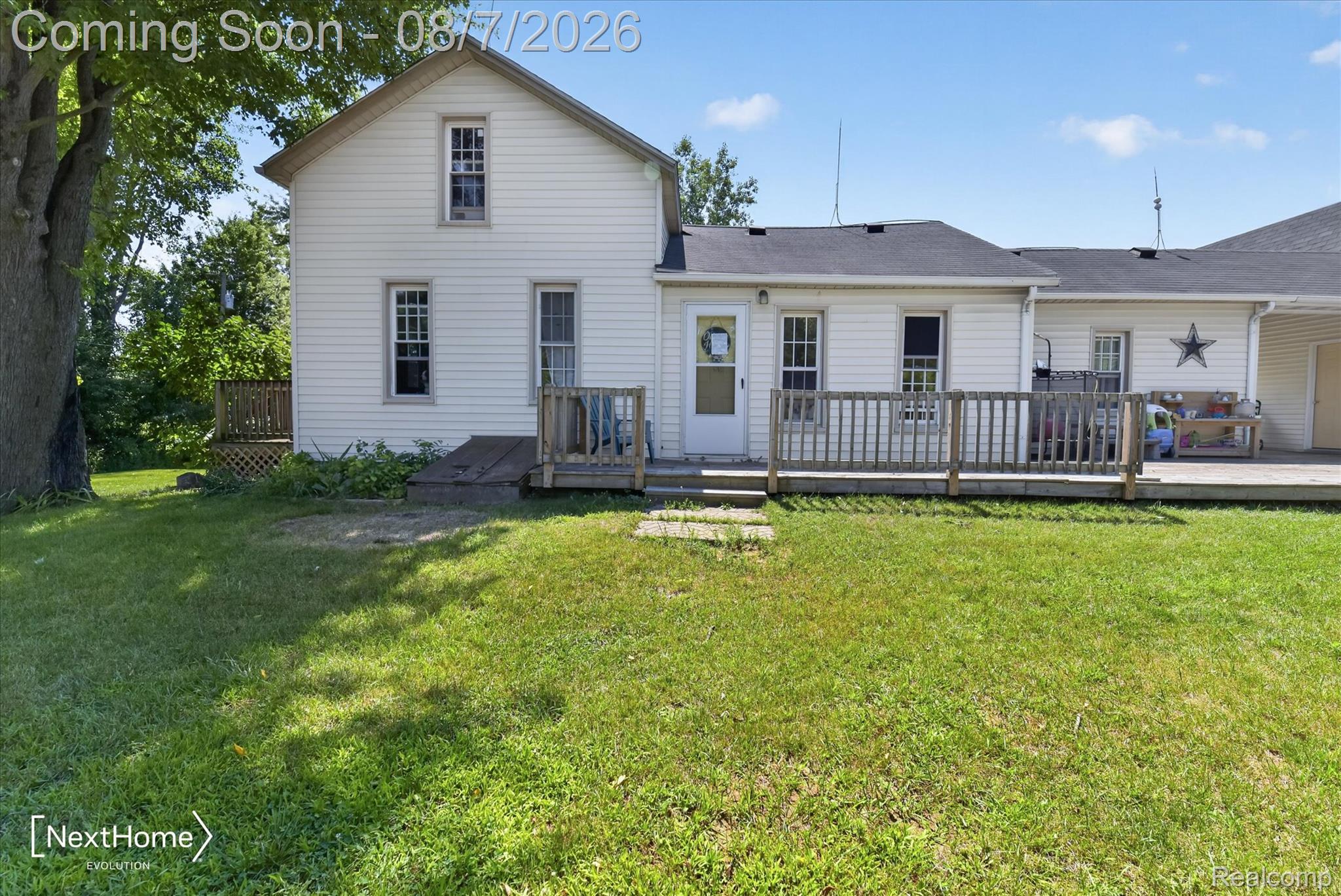 23740 Carleton West Road Belleville, MI 48111 - Photo 1 of 58 Charming farmhouse-style home featuring a classic white exterior with black-trimmed windows, a covered front porch with railings, and a spacious, level lawn framed by mature shade trees