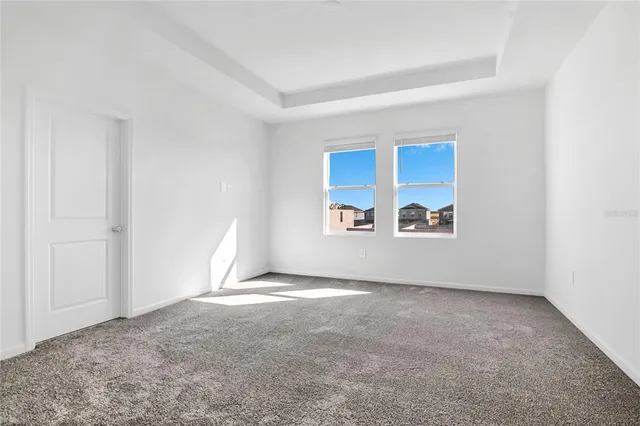 a view of a big room with window and chandelier fan