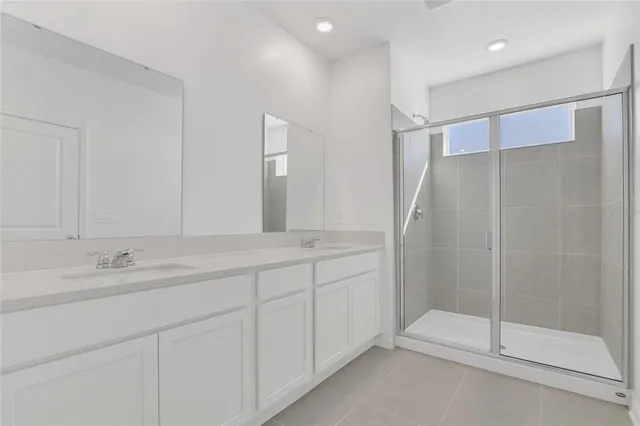 a spacious bathroom with a shower sink and mirror
