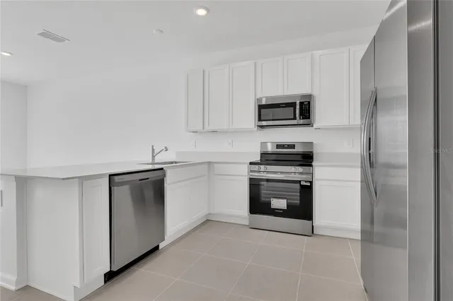 a kitchen with cabinets stainless steel appliances and a counter space