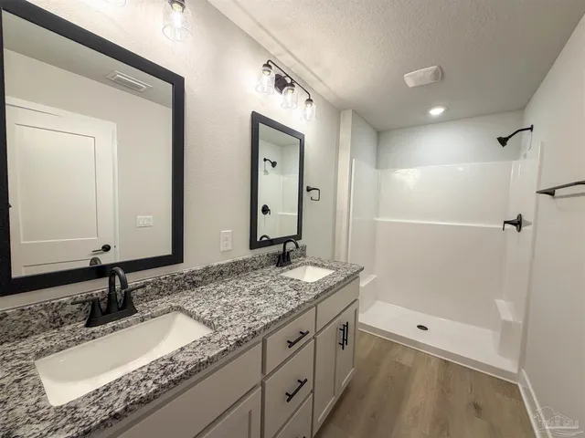 a bathroom with a granite countertop sink mirror and double