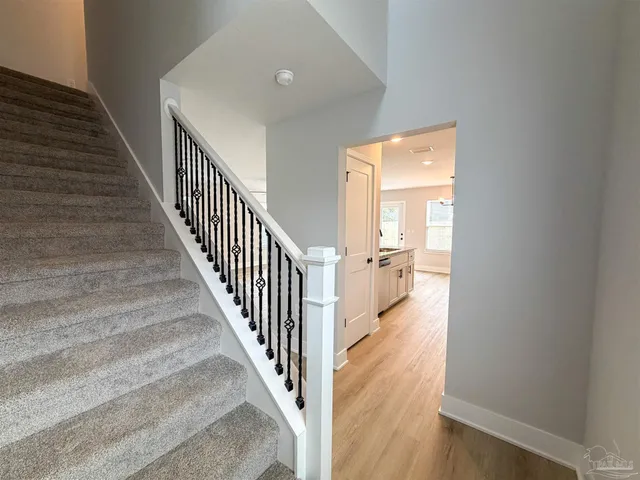 a view of a hallway with wooden floor and staircase