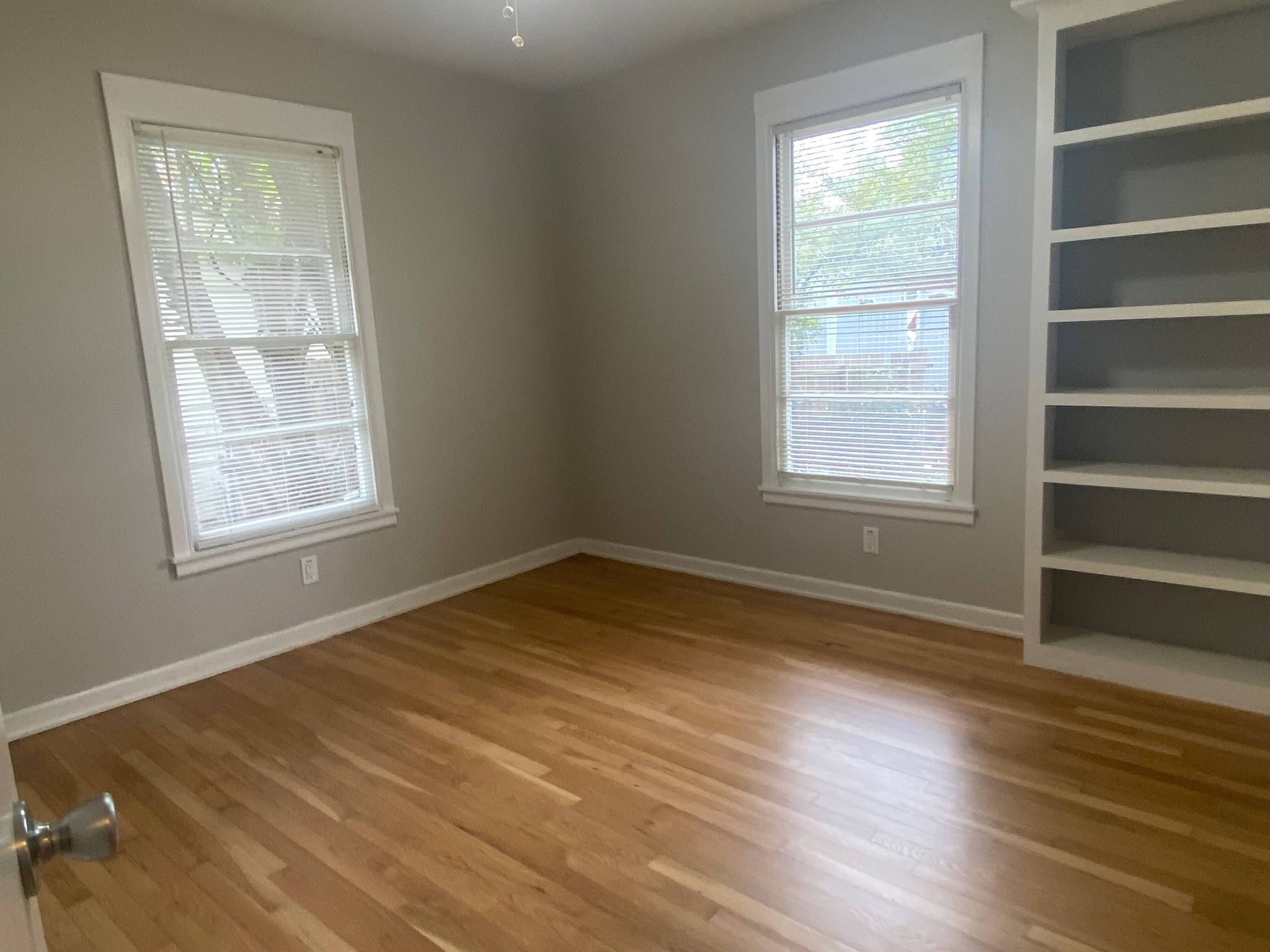 1818 South 39th Street Temple, TX 76504 - Photo 11 of 15 an empty room with wooden floor and windows