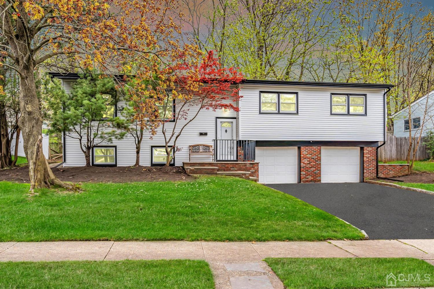 a front view of a house with a yard and trees