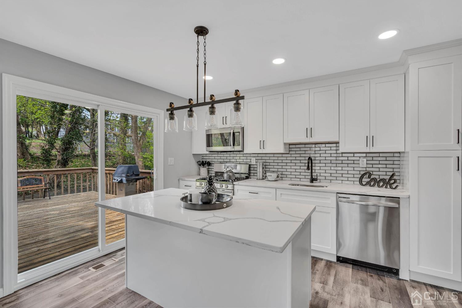 45 Harmon Road Edison, NJ 08837 - Photo 13 of 44 a kitchen with stainless steel appliances white cabinets a sink and wooden floors