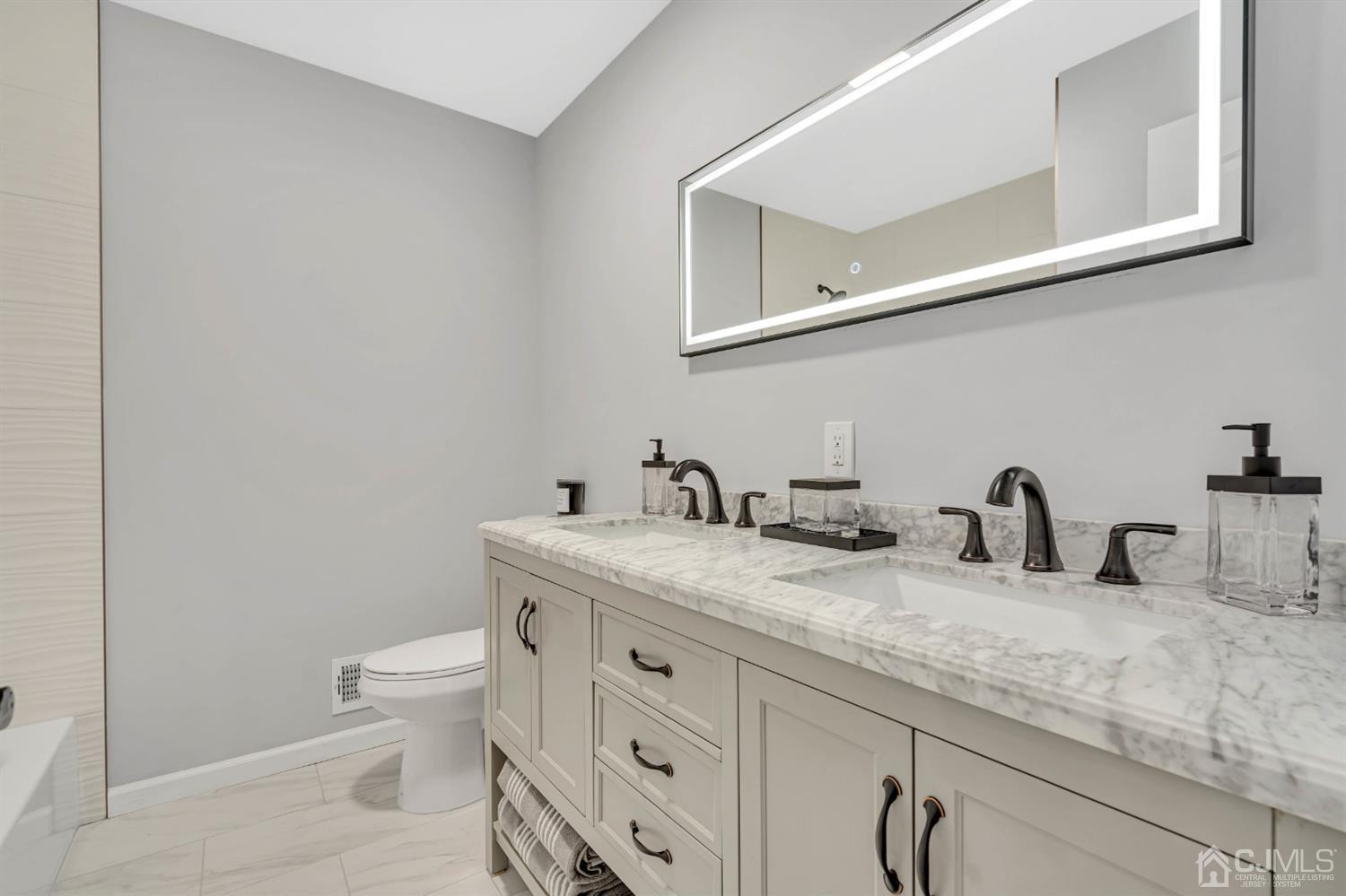45 Harmon Road Edison, NJ 08837 - Photo 26 of 44 a bathroom with a granite countertop sink and a toilet