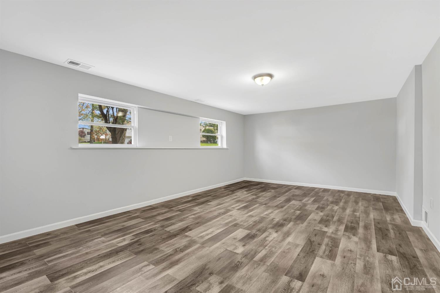 45 Harmon Road Edison, NJ 08837 - Photo 33 of 44 a view of an empty room with wooden floor and a window