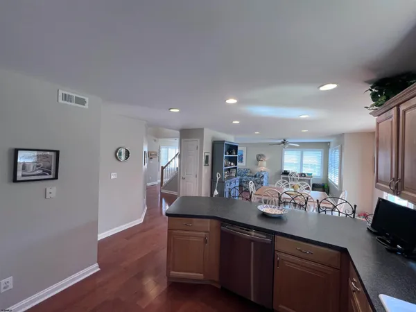 a kitchen with stainless steel appliances granite countertop a sink dishwasher stove and wooden floor