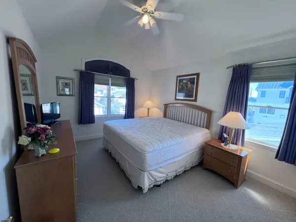 a bedroom with a bed mirror and window