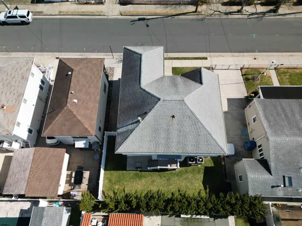 an aerial view of residential houses with outdoor space and parking