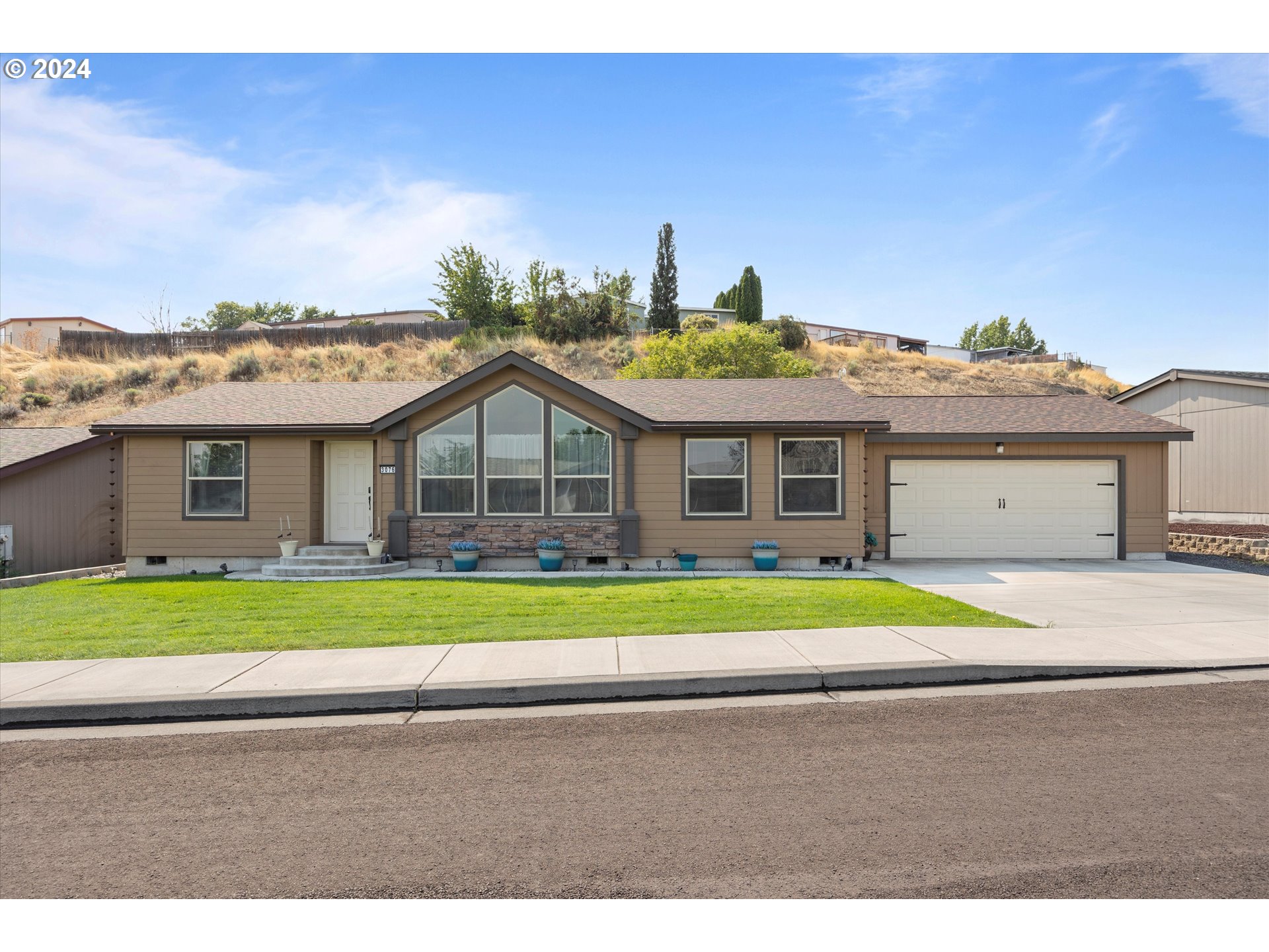 3076 Southwest River View Drive Pendleton, OR 97801 - Photo 1 of 37 a front view of a house with a yard and garage