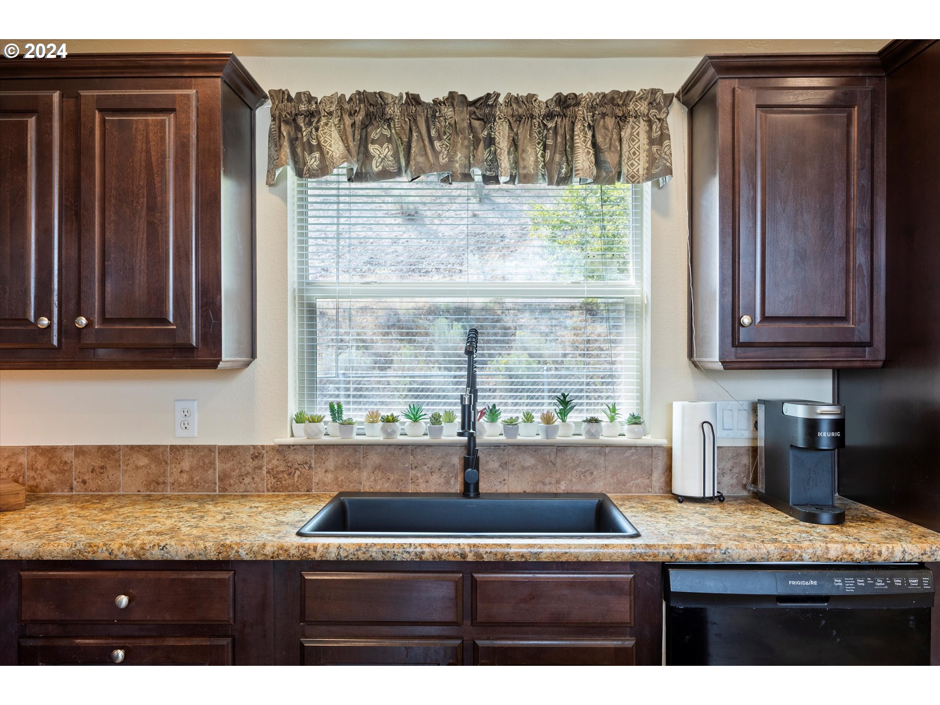 3076 Southwest River View Drive Pendleton, OR 97801 - Photo 17 of 37 a kitchen with granite countertop a sink and a wooden cabinets