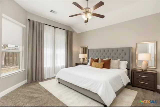 a bedroom with a large bed and a window