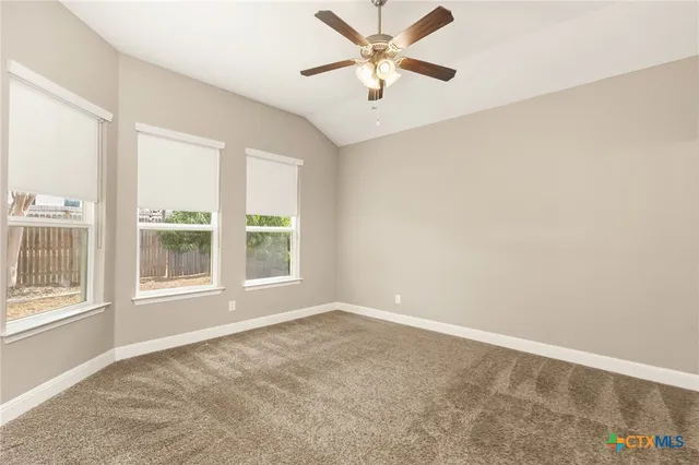 an empty room with a window and a fan