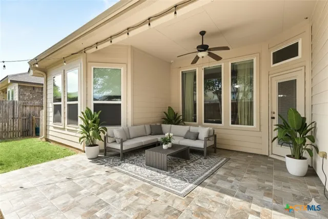 a living room with patio furniture and a potted plant
