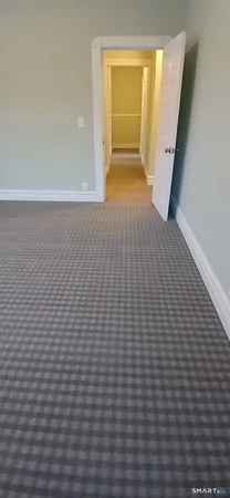 a view of a hallway with wooden floor and closet