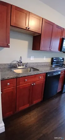 a kitchen with stainless steel appliances granite countertop a sink and wooden cabinets
