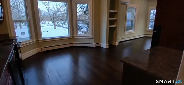 a view of a hardwood floor and a window in a room