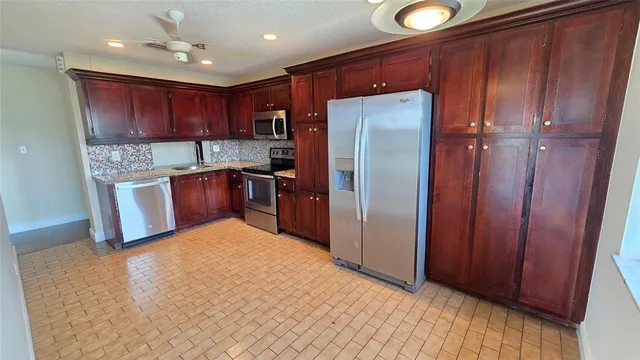 a kitchen with stainless steel appliances granite countertop a refrigerator and a sink