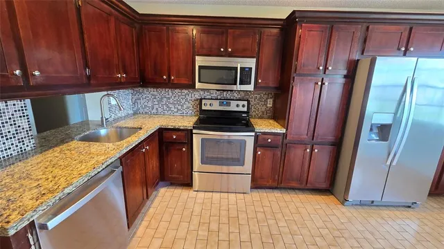 a kitchen with a refrigerator stove and cabinets