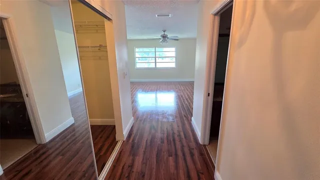 a view of a hallway with wooden floor and staircase
